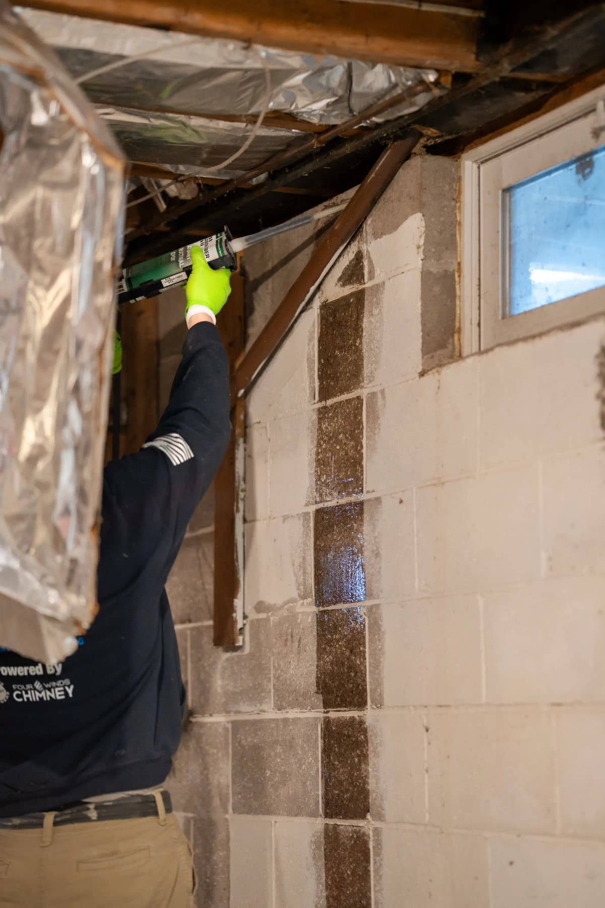 Technician applying carbon fiber strap from sill plate to footing